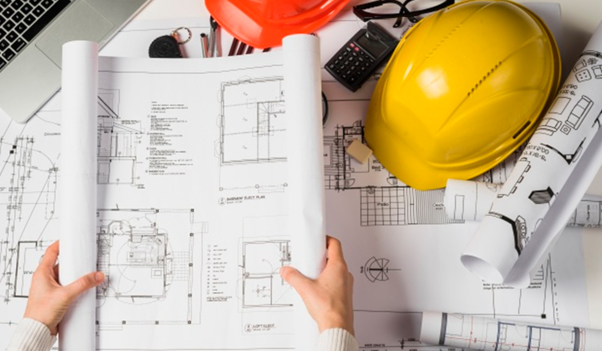 Engenheiros em uma obra analisando uma planta